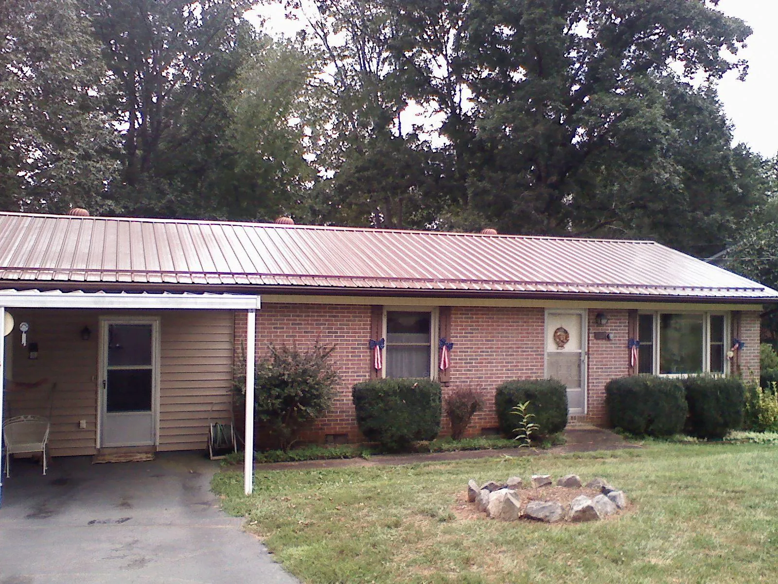 Bronze metal roof and carport on a brick ranch home — Roof Repair work by our crew in Cooperstown